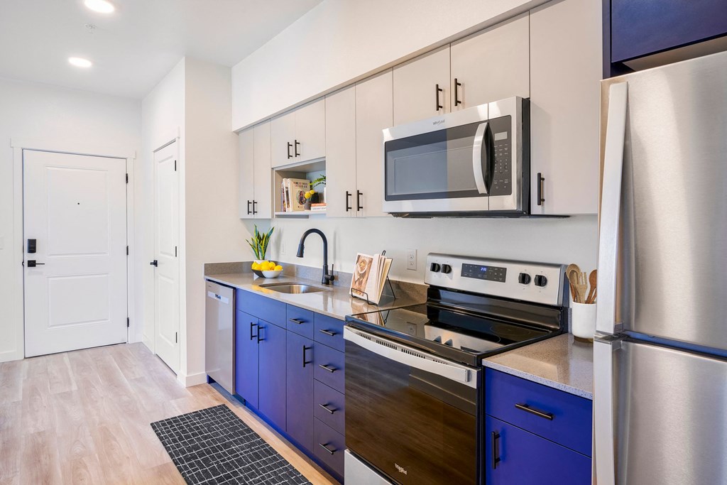 a modern kitchen with blue cabinets and stainless steel appliances