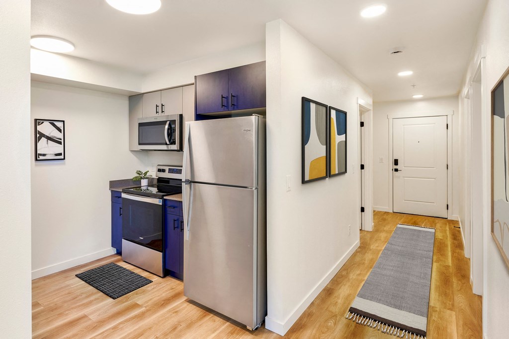 a renovated kitchen with stainless steel appliances and blue cabinets