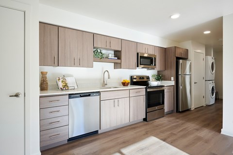 A modern kitchen with wooden cabinets and stainless steel appliances.