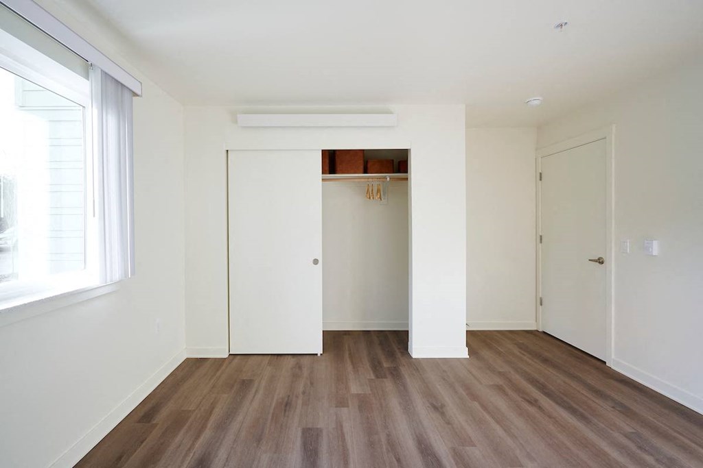 an empty living room with white walls and wood floors