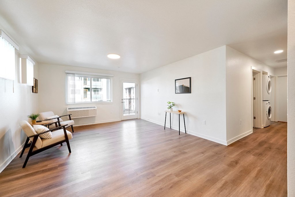 a living room with white walls and a hard wood floor