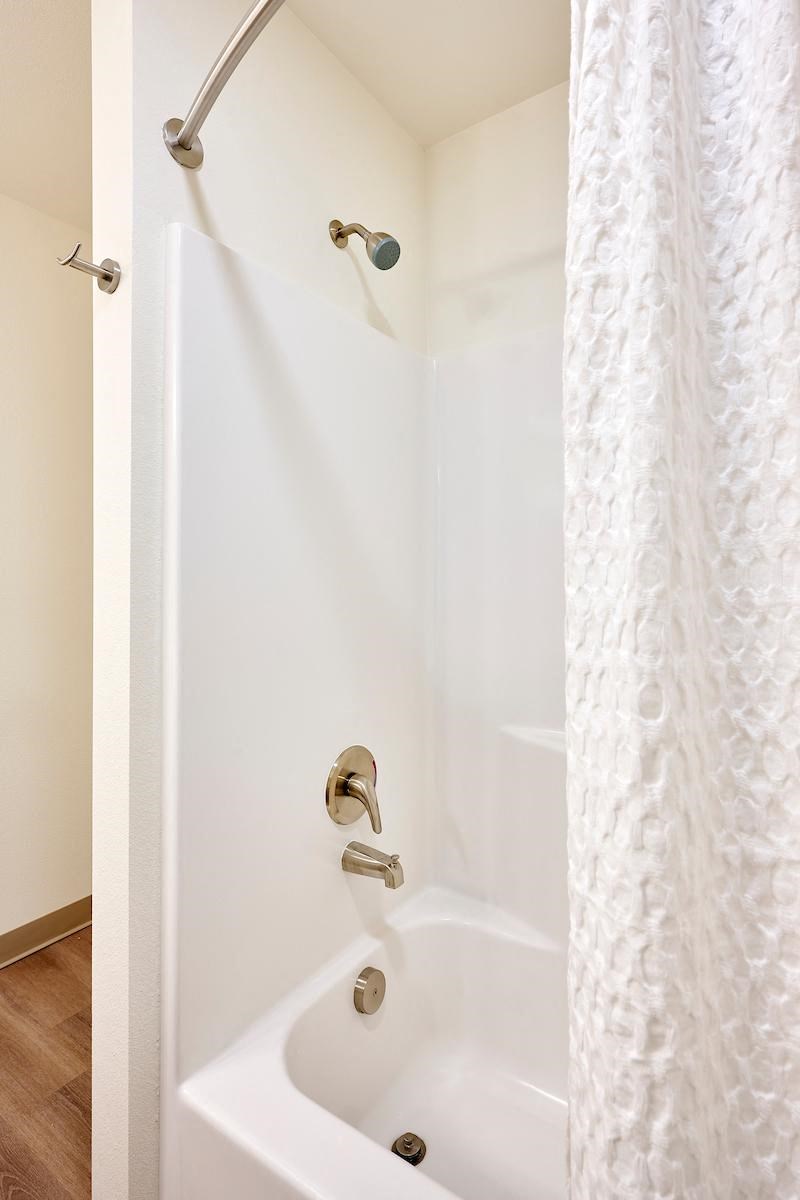 a white shower in a bathroom with a shower curtain