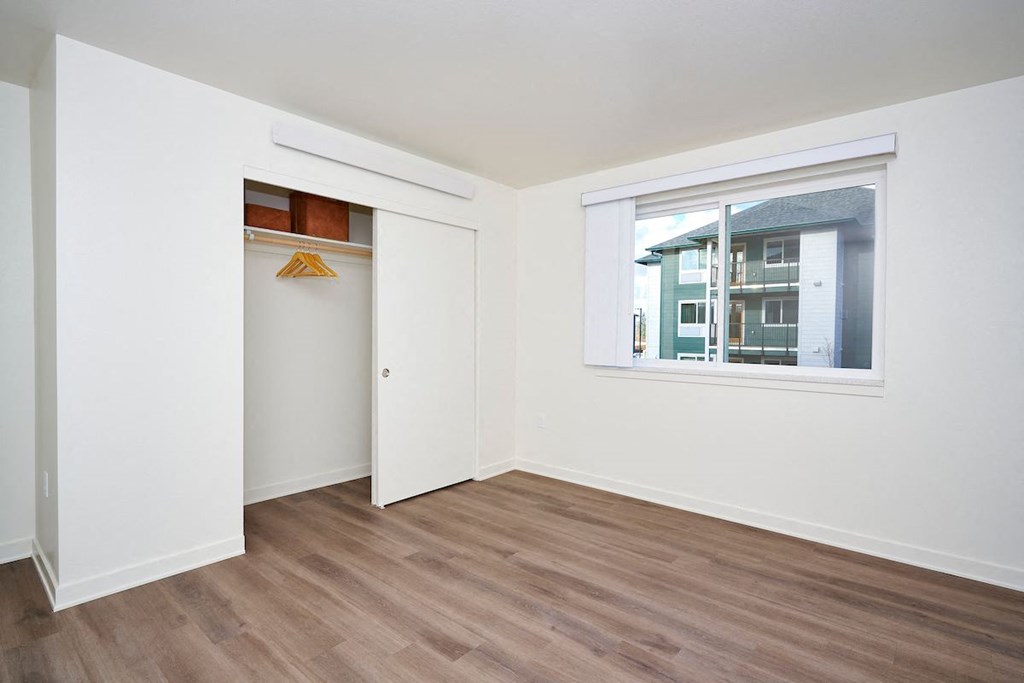 a bedroom with a window and a door to a closet