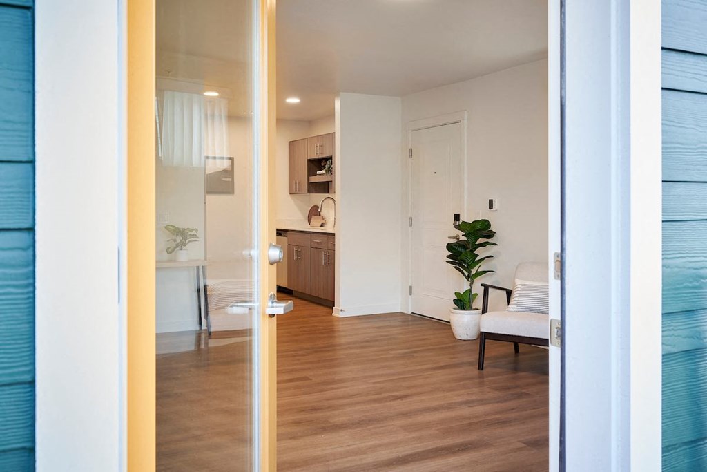 a view of a living room and a kitchen from a door