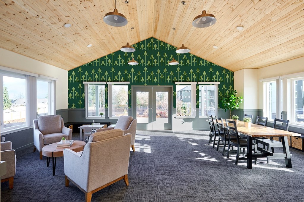 a large room with chairs tables and chairs and a wall covered in green wallpaper