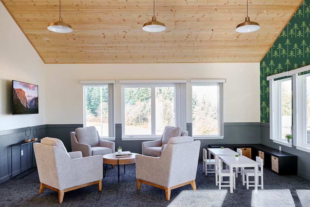 a living room with chairs and tables and a wooden ceiling