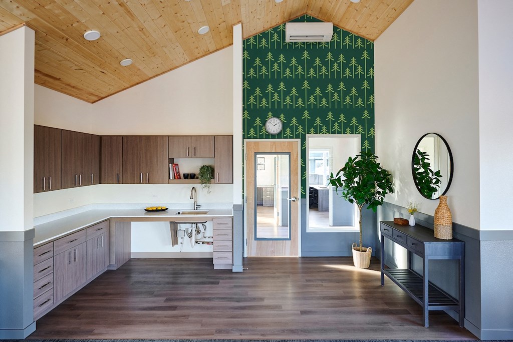a kitchen with white cabinets and a green wallpaper