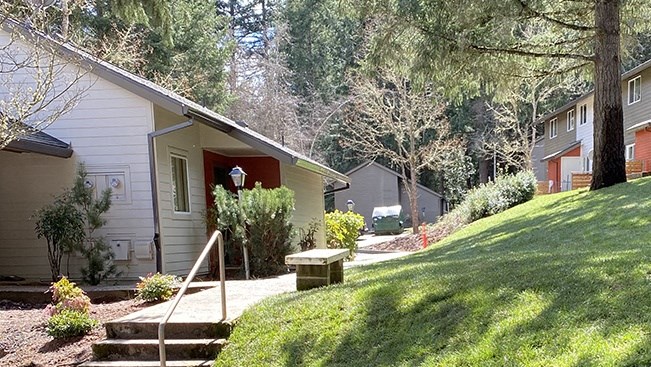 a small house on the side of a hill with a sidewalk