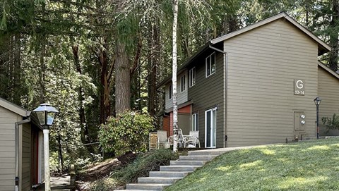 a house with stairs and a yard with trees