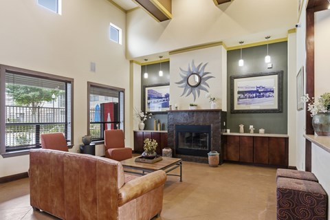 A living room with a fireplace and a large sun design on the wall.