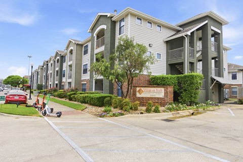 A row of apartment buildings with a sign that says "Villages at Hillcrest".