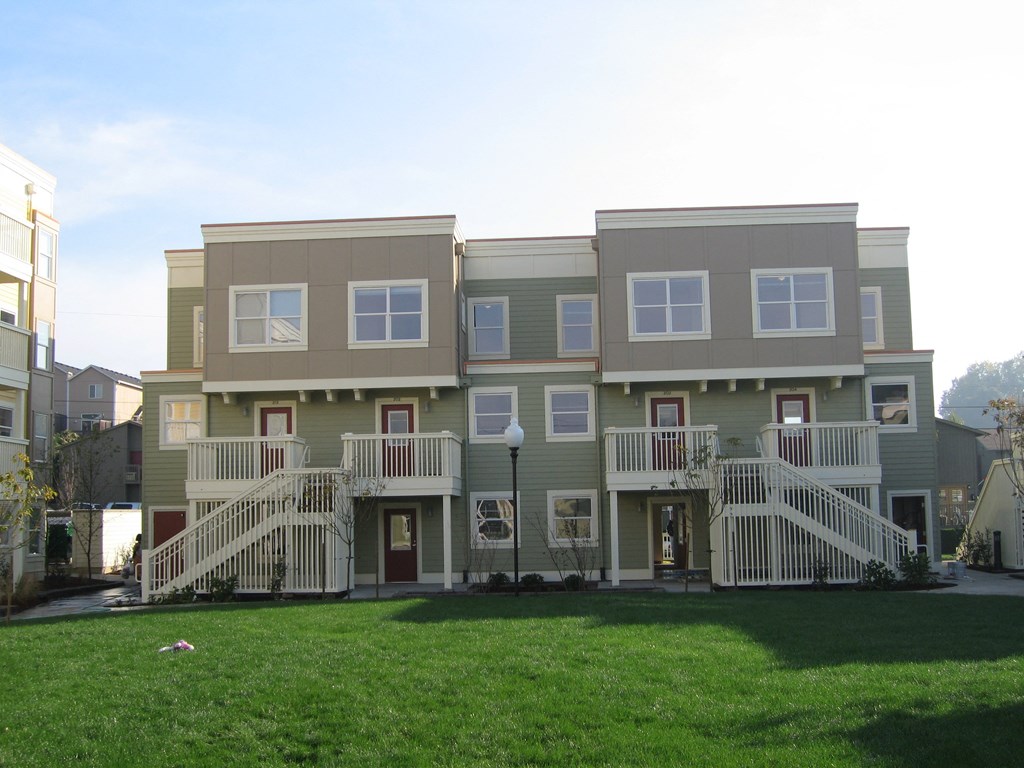 a large apartment building with a yard in front of it