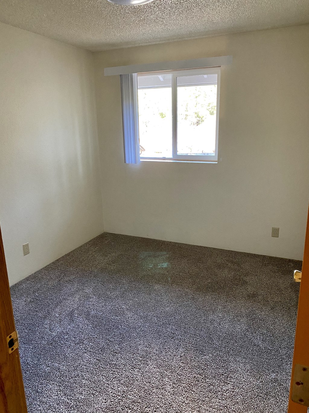 an empty room with a window and gravel floor