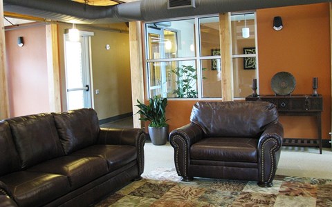 a living room with two brown leather couches
