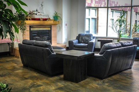 A living room with a fireplace and two couches.