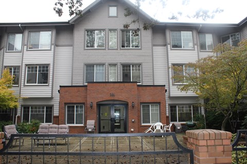 A grey building with a black door and windows.