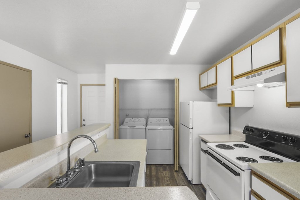 A kitchen with white appliances and a white countertop.