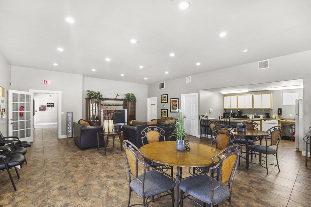 A dining room with a table surrounded by chairs.