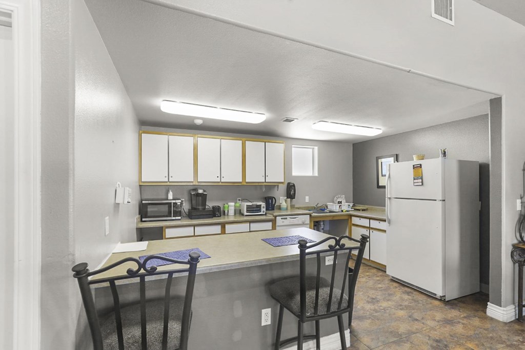 A kitchen with a table and chairs.