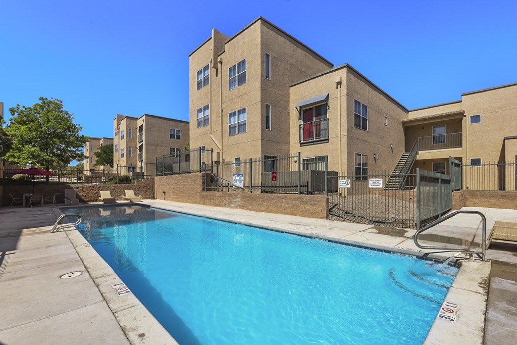 A swimming pool is located in front of a building.