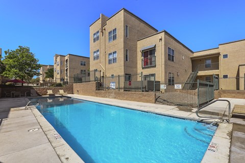 A swimming pool is located in front of a building.