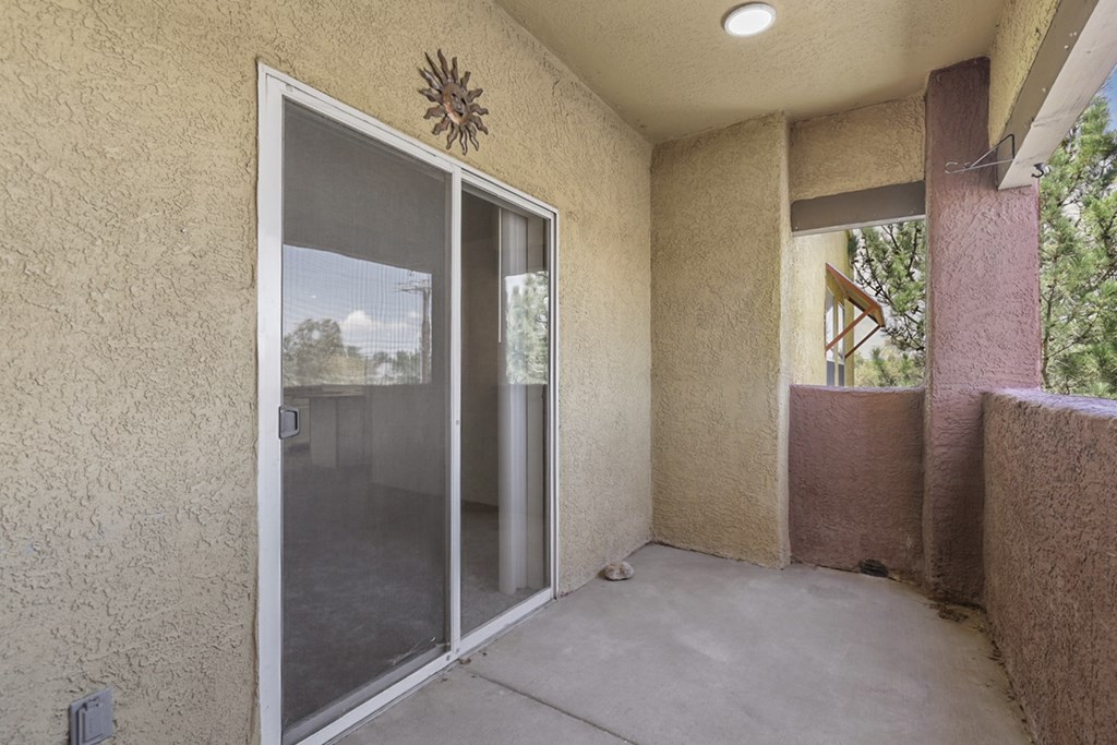A patio area with a sliding glass door and a wall-mounted fan.