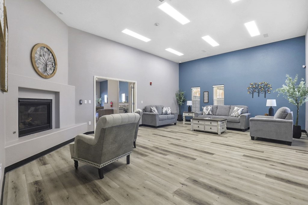 A living room with a fireplace and grey furniture.