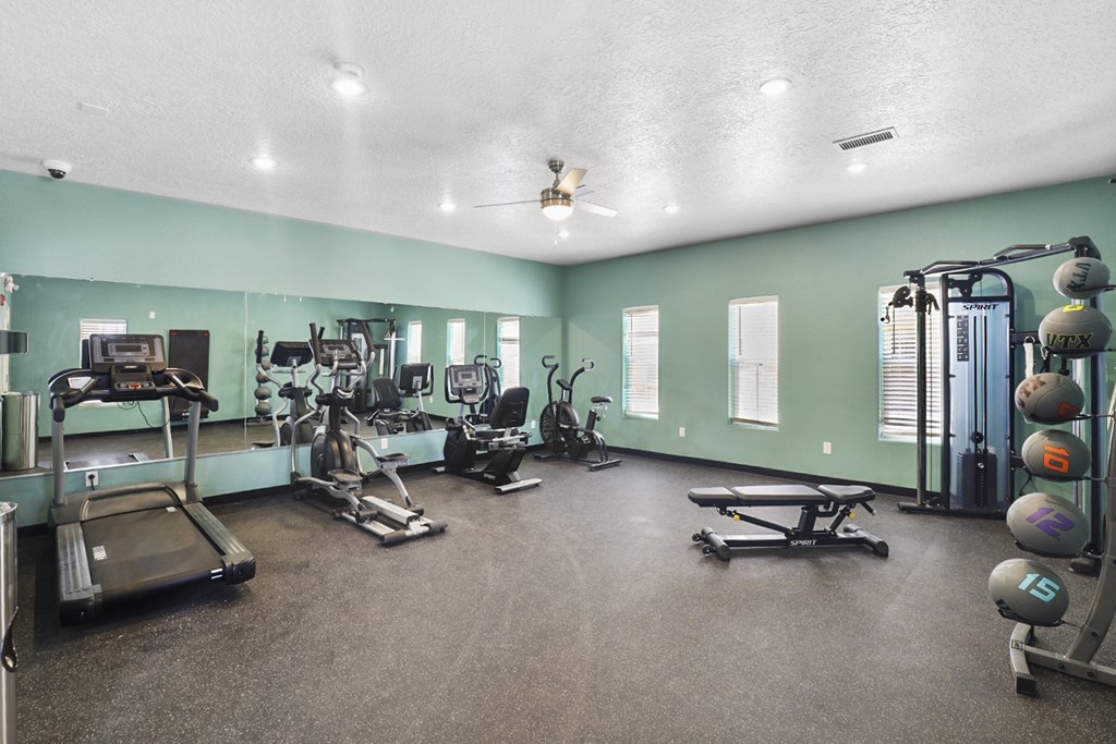 A spacious gym with a variety of equipment including treadmills, weights, and exercise machines.