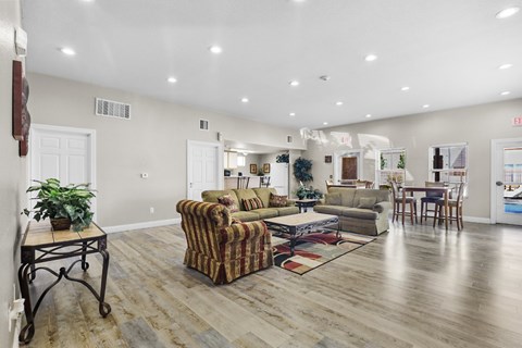 A living room with a striped couch and a wooden floor.