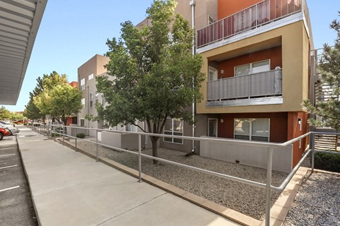 A building with a balcony and a tree in front of it.