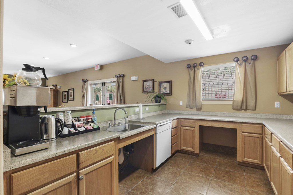 A kitchen with brown cabinets and a black coffee maker.