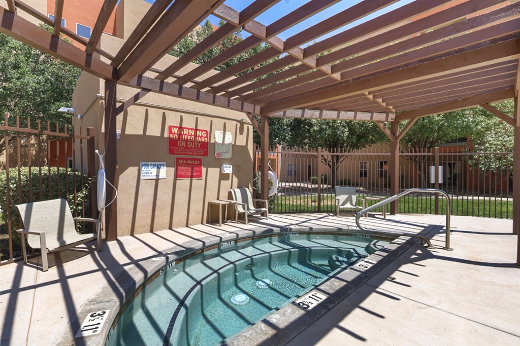 A pool with a wooden pergola over it.
