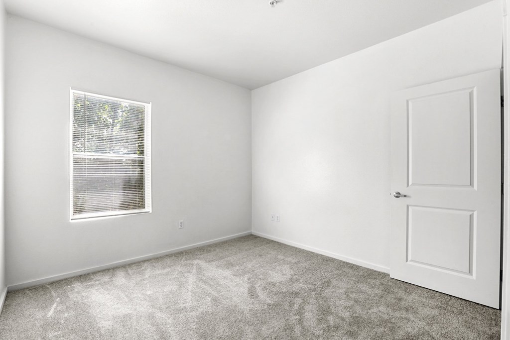 A white room with a door and a window.