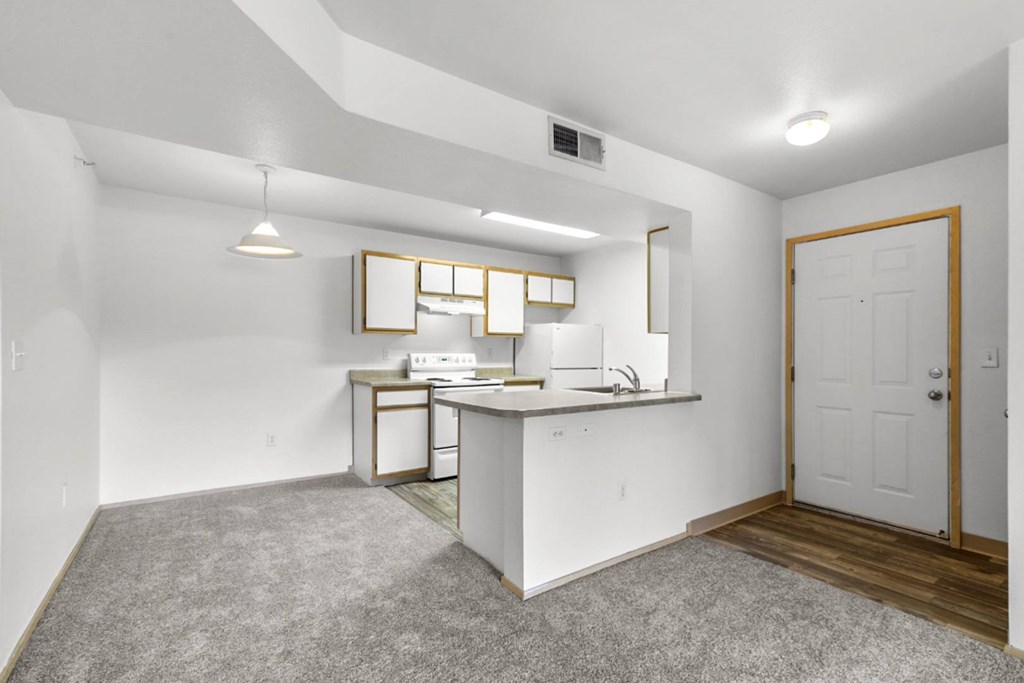 A small kitchen with white appliances and a white countertop.