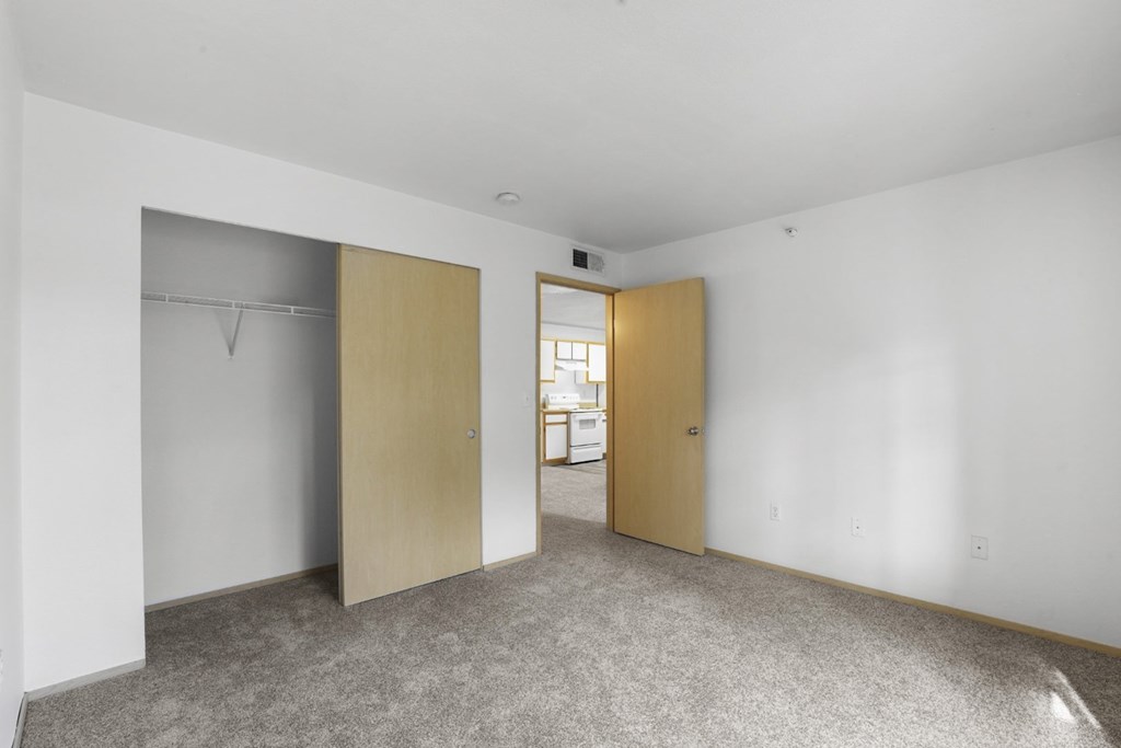 A room with a carpeted floor and two closed doors.