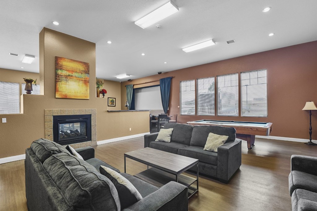A living room with a grey couch and a fireplace.