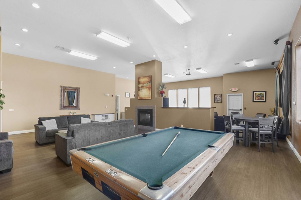 A room with a pool table and a fireplace.