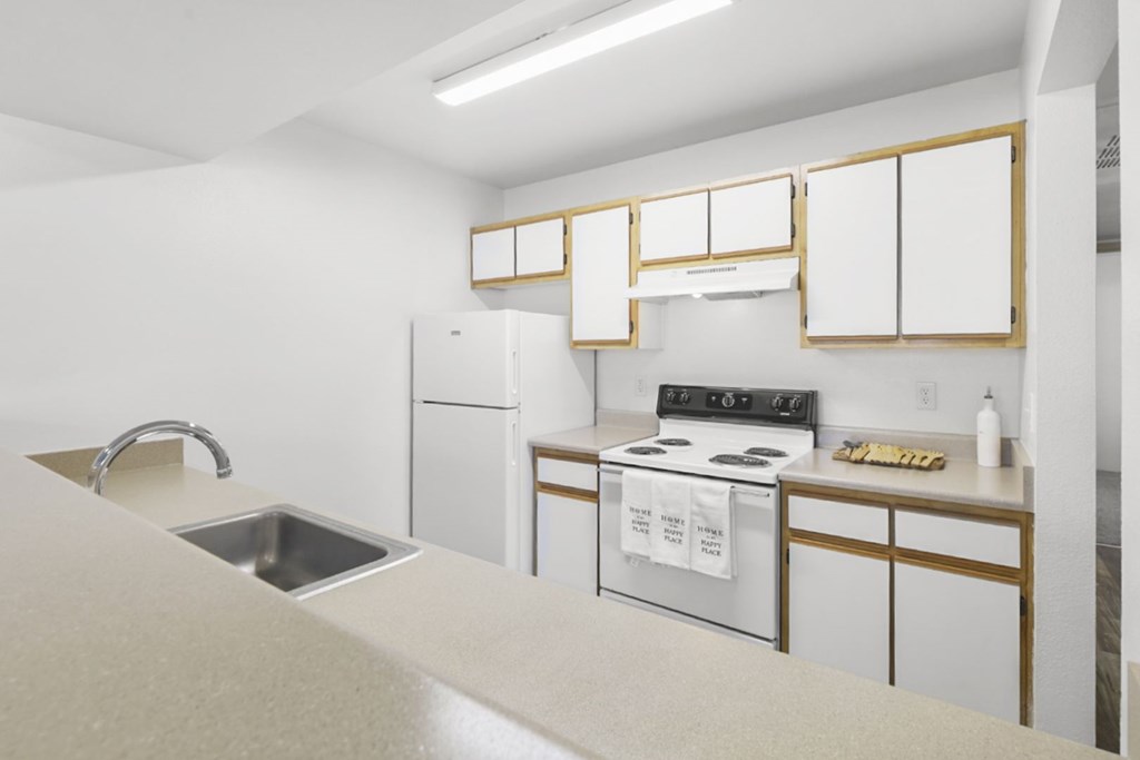 A kitchen with white appliances and cabinets.