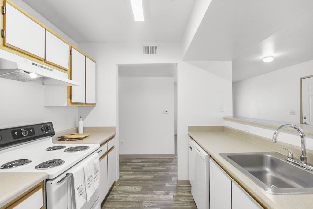 A kitchen with white cabinets and a black stove top.