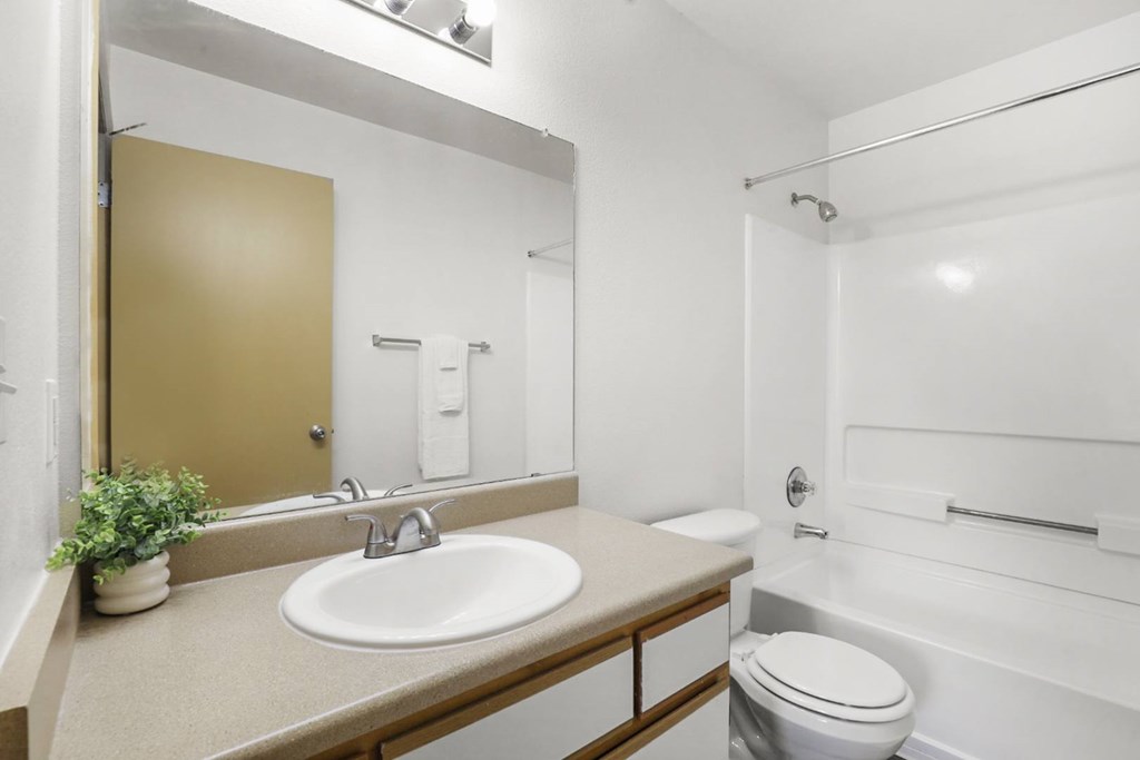 A bathroom with a sink, toilet, and bathtub.