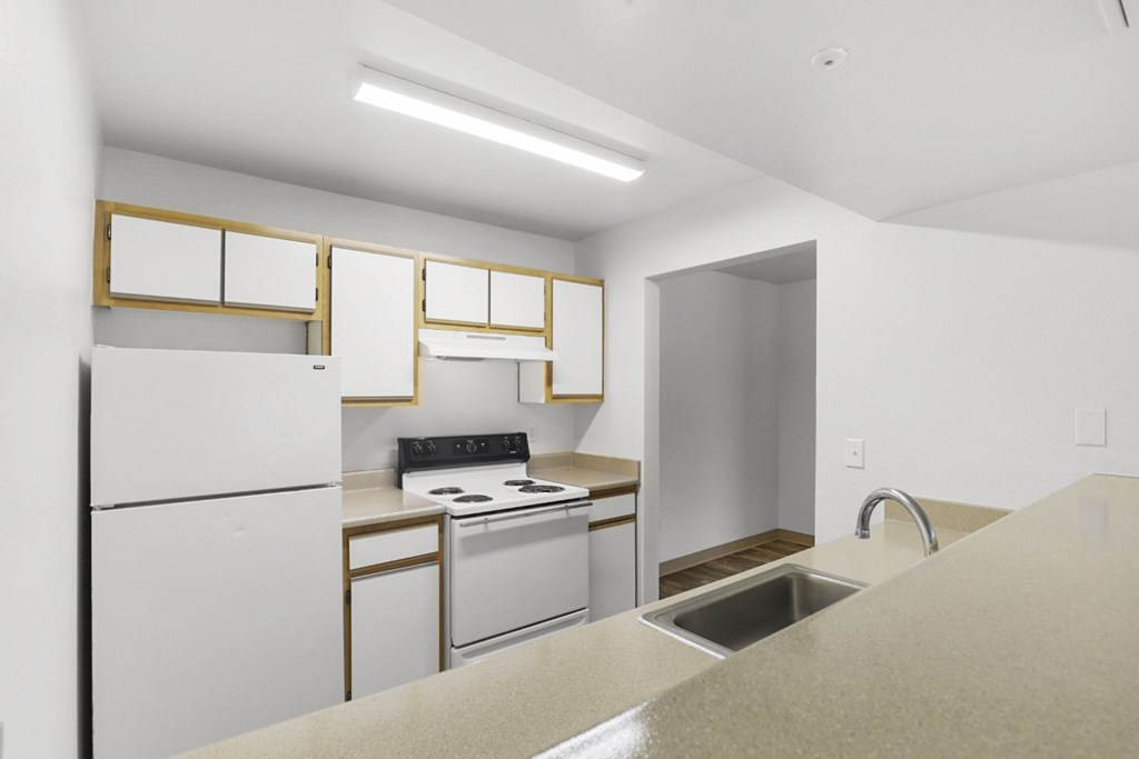 A kitchen with white appliances and a sink.