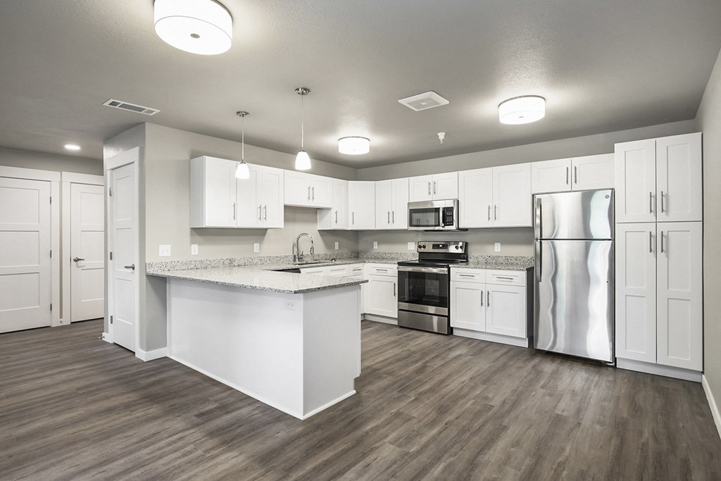 a large kitchen with white cabinets and stainless steel appliances