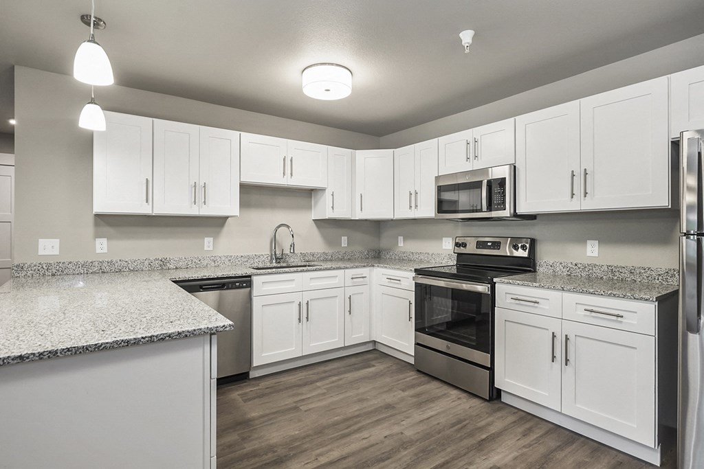 a large kitchen with white cabinets and stainless steel appliances