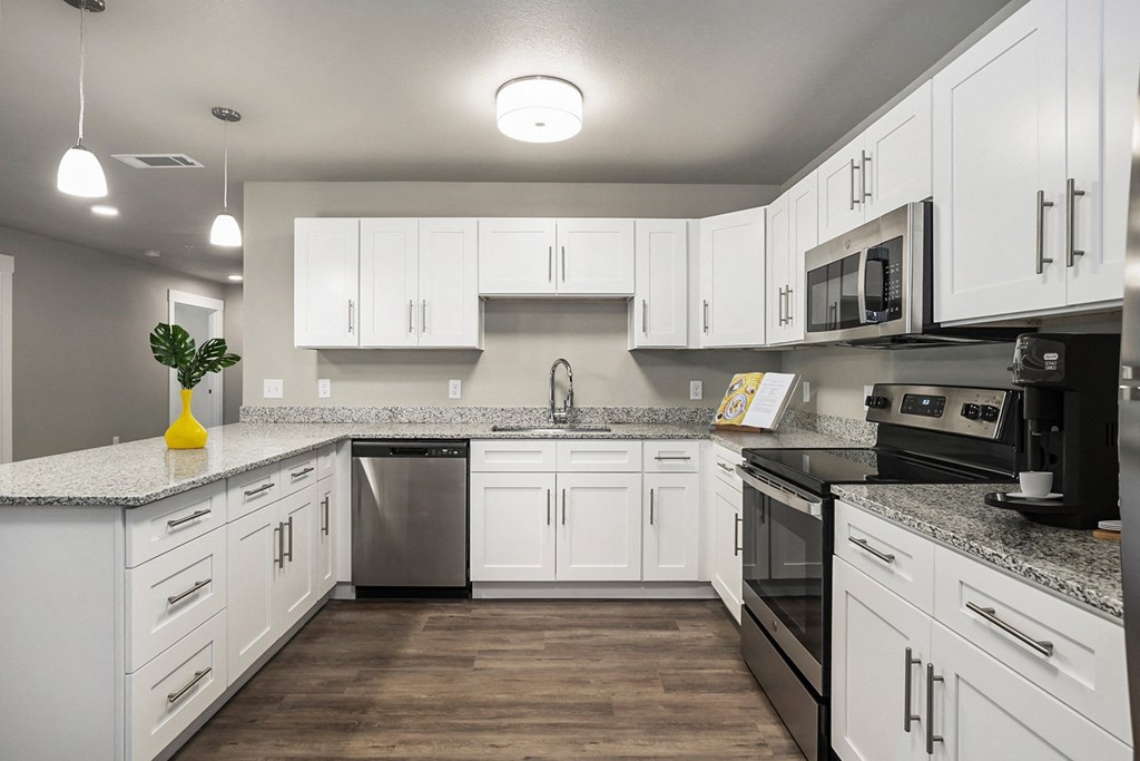 an empty kitchen with white cabinets and stainless steel appliances