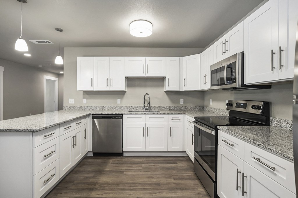 a large kitchen with white cabinets and stainless steel appliances