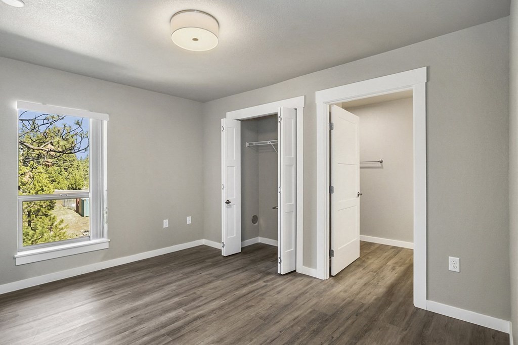 a bedroom with hardwood floors and grey walls