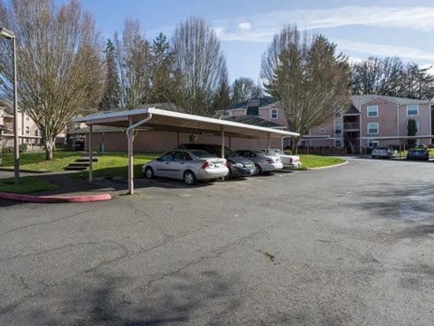 A parking lot with cars and a building in the background.