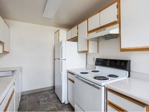 A kitchen with white appliances and wooden cabinets.