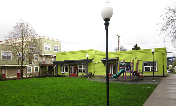 a playground in front of a green building