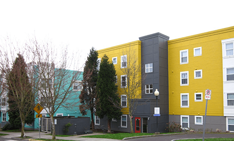 a yellow and gray building on the side of a street